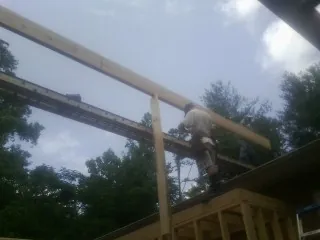 Carpenter setting a ridge beam over a new addition frame — Ice Dam Removal by Roofing Brothers in Braddock