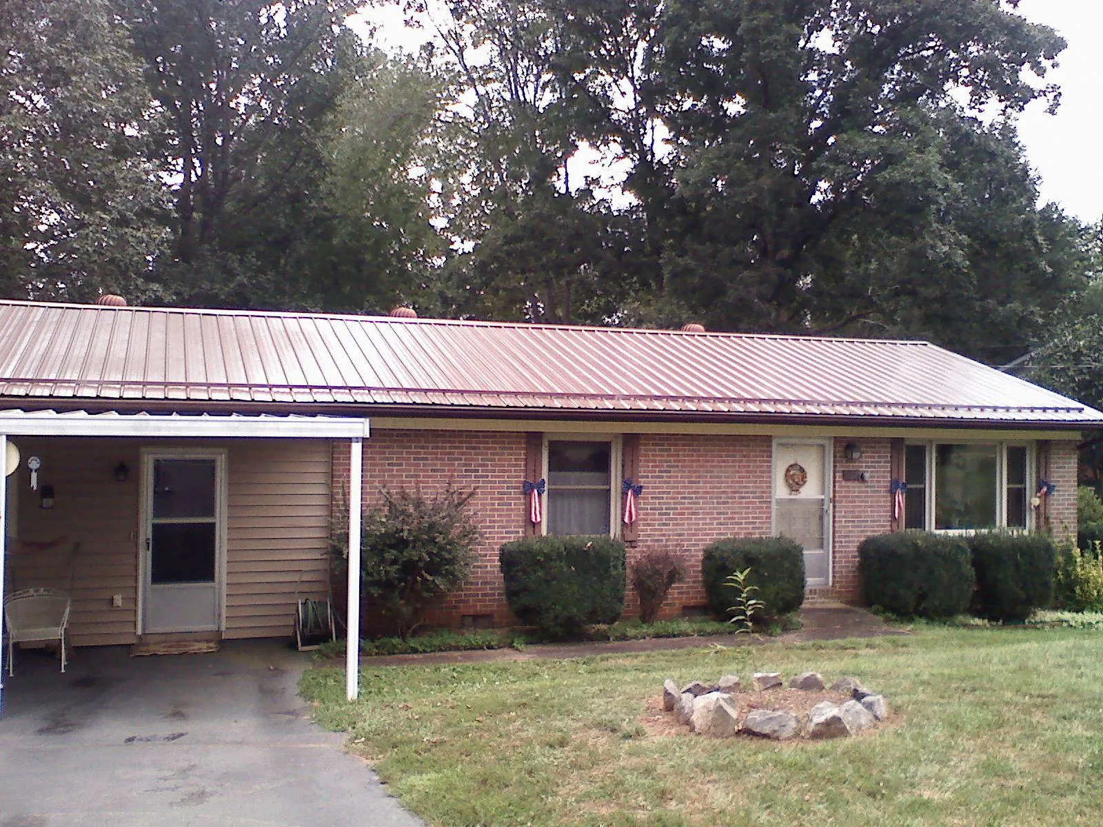 Bronze metal roof and carport on a brick ranch home — Roof Repair work by our crew in Braddock